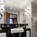 Modern bathroom with sleek black and white design and marble accents.