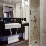 Modern bathroom with marble walls and sleek fixtures.