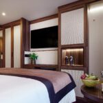 Elegant hotel room with modern decor and a large TV.