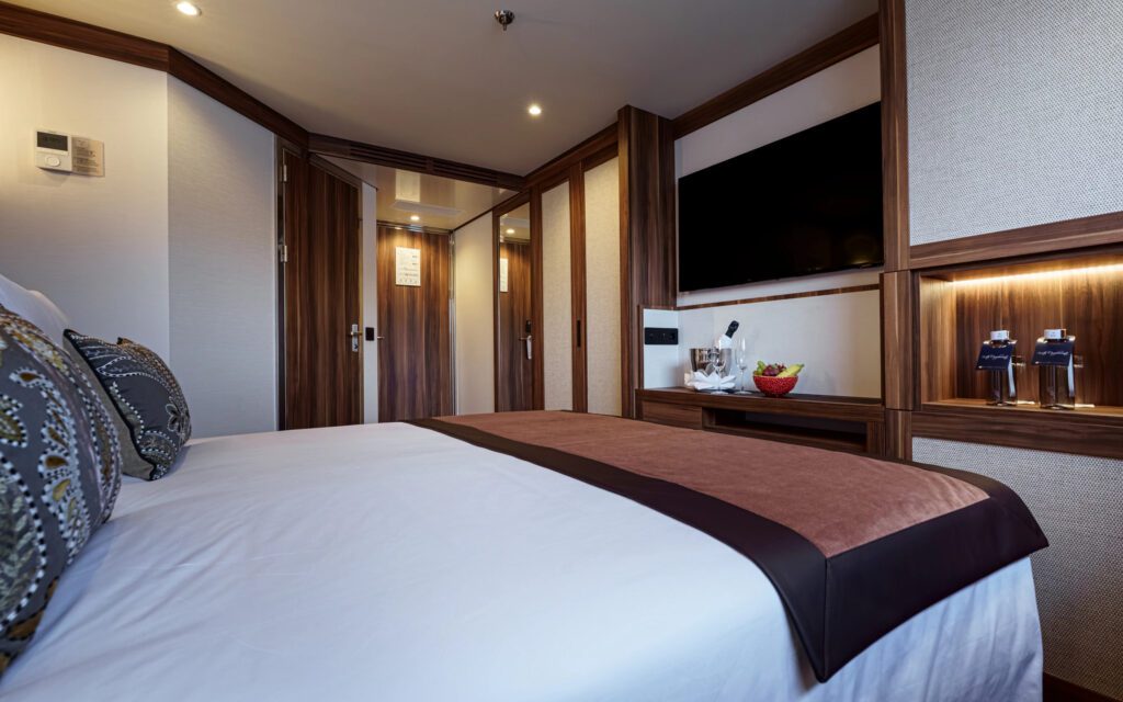 Cozy hotel room with a large bed and modern wood-paneled walls.