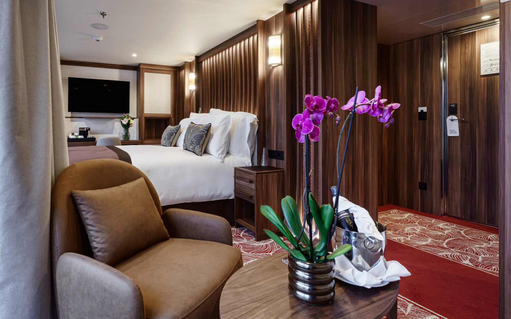 Cozy hotel room with elegant decor and vibrant orchids.