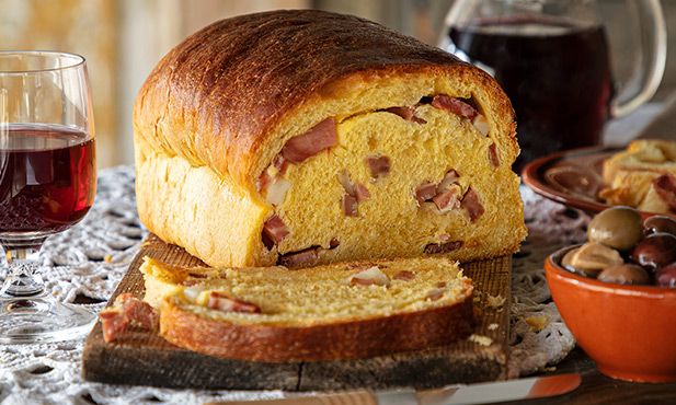 A loaf of bread with sausage slices inside, partially sliced.