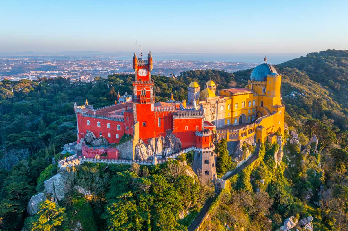 Colorful Pena Palace atop a lush hill overlooking Sintra, Portugal.