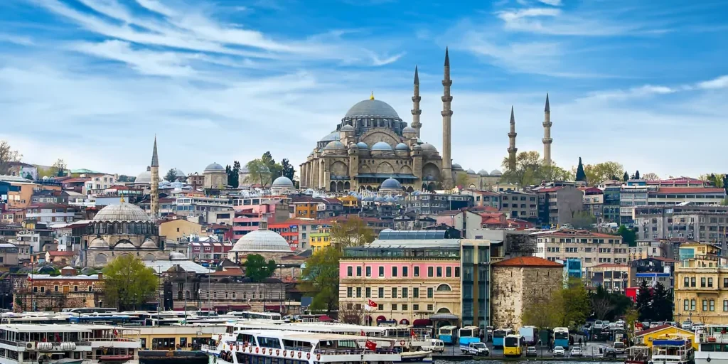 View of Istanbul skyline with historic mosque and boats on the water.